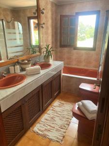 un bagno con due lavandini e un grande specchio di Authentic Villa with amazing pool a Santa Gertrudis de Fruitera