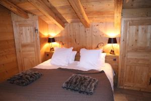 a bedroom with a bed in a room with wooden walls at Chez La Fine in Les Gets