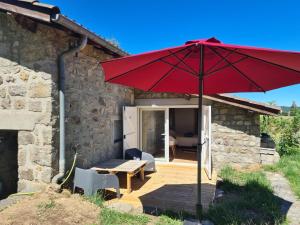 a red umbrella in front of a house at Room lover Les Chaizes in Saint-Romain-Lachalm