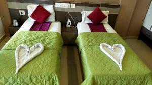 two beds with hearts on them in a hotel room at Alfa Inn in Nedumbassery