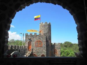 a castle with a flag on top of it at La Fortaleza De Haro in Puerto Ayora