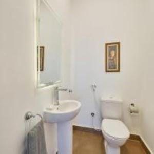 La salle de bains blanche est pourvue de toilettes et d'un lavabo. dans l'établissement Golden Lake Marina Hotel, à El Alamein