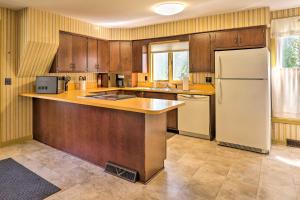 a kitchen with wooden cabinets and a white refrigerator at Sodus Point Escape - Walkable to Lake Ontario in Sodus