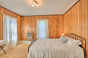 a bedroom with a bed with wooden walls and a window at Sodus Point Escape - Walkable to Lake Ontario in Sodus
