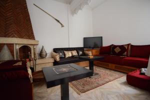 a living room with a couch and a fireplace at RYAD RDATE LWALIDINE in Marrakesh