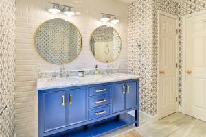 a bathroom with a blue vanity and two mirrors at Lakefront Homer Abode with Patio and Backyard! in Homer +36 photos
