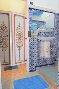 a bathroom with blue and white tiles and a sink at RYAD RDATE LWALIDINE in Marrakesh
