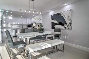 a kitchen and dining room with a table and chairs at Sunny Isles Resort Condo Less Than Half-Mi to Beach! in Miami Beach