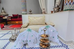 a living room with a bed with a tray of cookies at RYAD RDATE LWALIDINE in Marrakesh