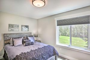 a bedroom with a bed and a large window at Brand New Red Lodge Home with Private Hot Tub! in Red Lodge