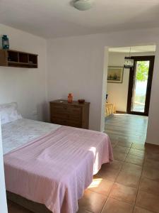 Un dormitorio con una cama con una manta rosa. en Best location apt in Old town with walking distance to the beach, en Centro histórico de Alónnisos