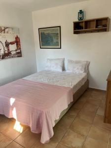 1 dormitorio con 1 cama con manta rosa en Best location apt in Old town with walking distance to the beach, en Centro histórico de Alónnisos
