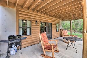 a patio with a table and chairs and a stove at Rural Wooded Cabin Near Trophy Trout Fishing! in Norfork