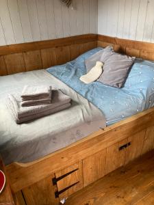 レクサムにあるBerwyn Shepherds Hutのベッド(青いシーツ、タオル付)