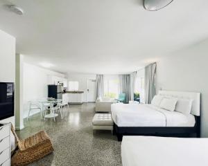 a white bedroom with a large bed and a living room at Tranquilo in Fort Lauderdale
