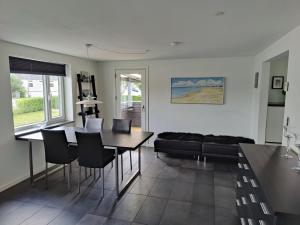 约灵Bjergby Guesthouse的带桌椅和沙发的客厅