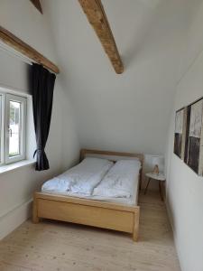 - une chambre avec un lit dans une pièce dotée d'une fenêtre dans l'établissement Bjergby Guesthouse, à Hjørring