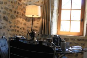 a room with a table with a lamp and a window at La petite Maison du Bonheur & Jacuzzi in Croze