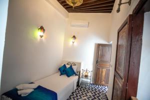 um quarto com uma cama com almofadas azuis em Dar Hafsa em Fez