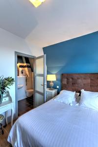 a bedroom with a large bed with a blue wall at Hotel Le Rayon Vert in Étretat