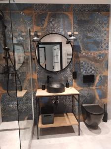 a bathroom with a sink and a mirror on a wall at Apartament Loftowy Głuszyca in Głuszyca