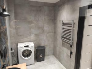 a small bathroom with a washing machine in it at Apartament Loftowy Głuszyca in Głuszyca
