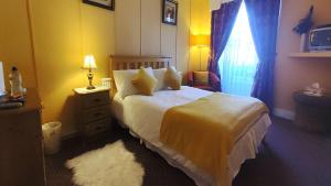 a bedroom with a white bed and a window at Inishross House in New Ross