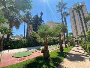 een park met palmbomen en een golfbaan bij Gemelos 22-2-24 in Benidorm