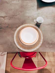 uma mesa com um prato em cima de uma cadeira vermelha em Locus Amoenus Apartment a pochi passi dagli Scavi em Pompeia