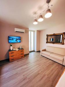 uma sala de estar com um sofá e uma televisão em Locus Amoenus Apartment a pochi passi dagli Scavi em Pompeia