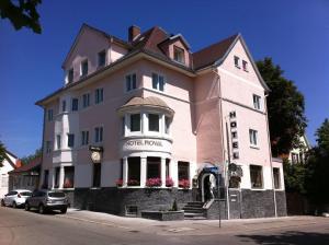 un grand bâtiment rose sur le côté d'une rue dans l'établissement Hotel Royal, à Villingen-Schwenningen