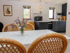 een keuken en eetkamer met een tafel en stoelen bij Baa Lamb Cottage in Burmarsh