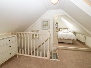 a attic bedroom with a bed and a staircase at Baa Lamb Cottage in Burmarsh