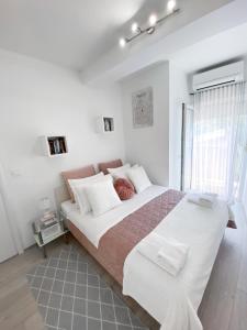Homey apartment with a view في سبليت: غرفة نوم بيضاء مع سرير كبير ونافذة