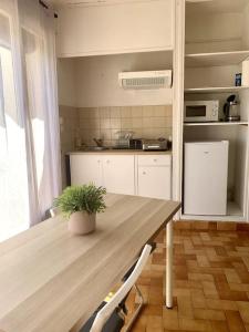 拉加爾德的住宿－La Garde : joli studio dans résidence，厨房配有木桌和植物