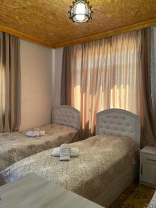 a bedroom with two beds and a window with curtains at Tatev Shinuhayr Hotel' in Shinuhayr