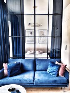 a blue couch with pillows in a living room at IDYLLA Apartamenty w sercu Wrocławia na Ostrowie Tumskim in Wrocław