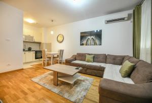 ein Wohnzimmer mit einem Sofa und einem Tisch in der Unterkunft Apartment Bono Lux City Kvart in Podgorica