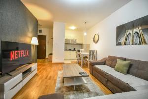 ein Wohnzimmer mit einem Sofa und einem TV in der Unterkunft Apartment Bono Lux City Kvart in Podgorica