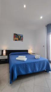 1 dormitorio con 1 cama azul y 2 toallas en Apartamentos Cala Azul La Móra, en Tarragona