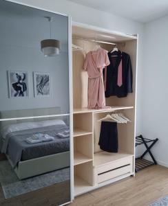 Claro Apartments - Prampolini 12 في ميلانو: غرفة ملابس مع مرآة وسرير