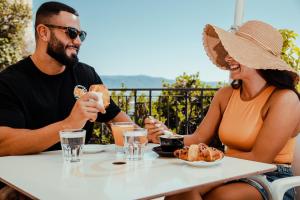 a man and woman sitting at a table eating food at Residenza Kastrum in Cagliari