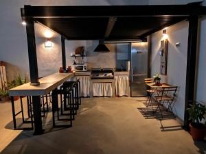 a kitchen with a bar and some tables and chairs at Alojamiento El Miajon de los Castúos in Valdesalor