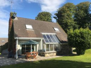 a house with a roof with a table and chairs at Idyllic 3-Bed House minutes from village & beach in Rathmullan