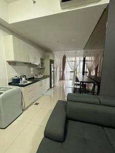a kitchen and living room with a couch and a table at Kyra Homestay Centrus SOHO Cyberjaya *wifi and pool* in Cyberjaya