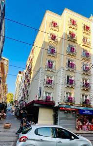 um carro branco estacionado em frente a um edifício em Flower Palace Hotel em Istambul