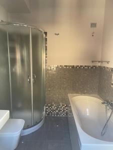 uma casa de banho com um chuveiro, uma banheira e um WC. em Sei ottavi em Gioiosa Marea