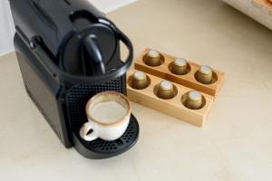 Eine Kaffeemaschine mit einer Tasse Kaffee neben einer Holzkiste in der Unterkunft Lotus Cave Villa in Fira