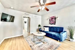 sala de estar con sofá azul y ventilador de techo en City Outside & Tranquility Inside, en Dallas