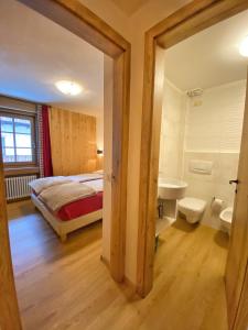 a bedroom with a bed and a bathroom with a sink at Chalet Monteneve Appartamento Toilà in Livigno